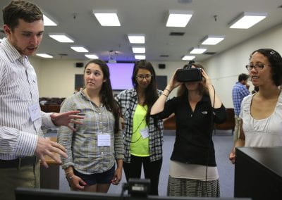 A group of 5 people one using a virtual reality glasses